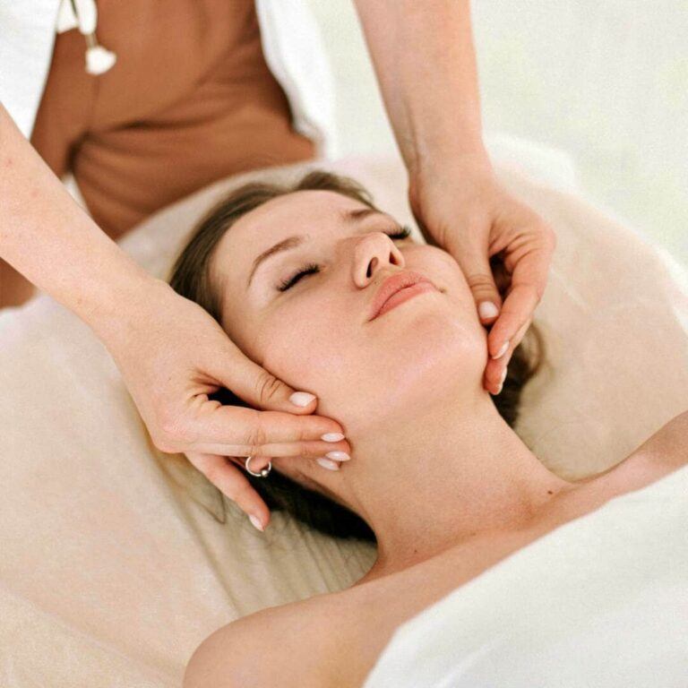 Mujer con los ojos cerrados disfrutando de un suave masaje facial en el Cortijo El Sarmiento – pura relajación y bienestar en Mojácar
